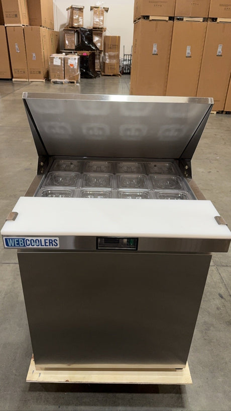 Stainless steel refrigerator on a wooden pallet in a warehouse setting