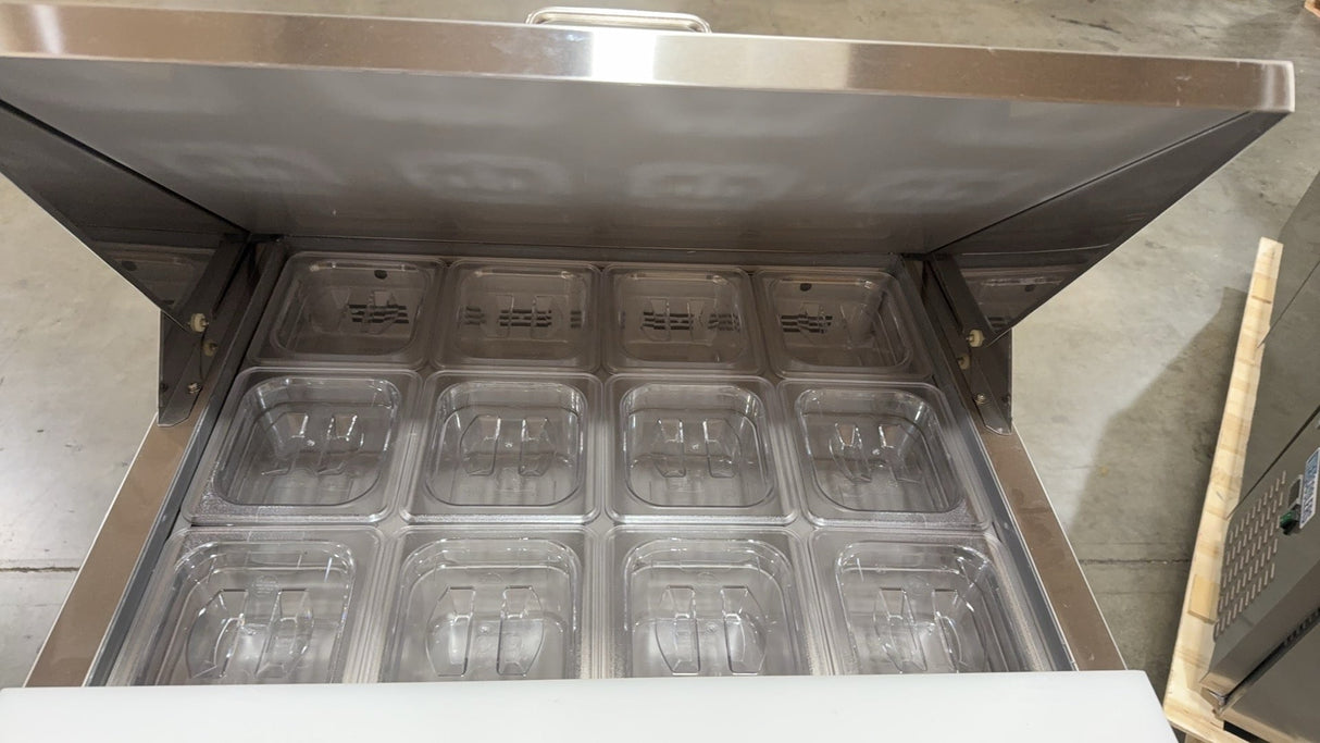 Stainless steel refrigerator with open door showing multiple compartments.