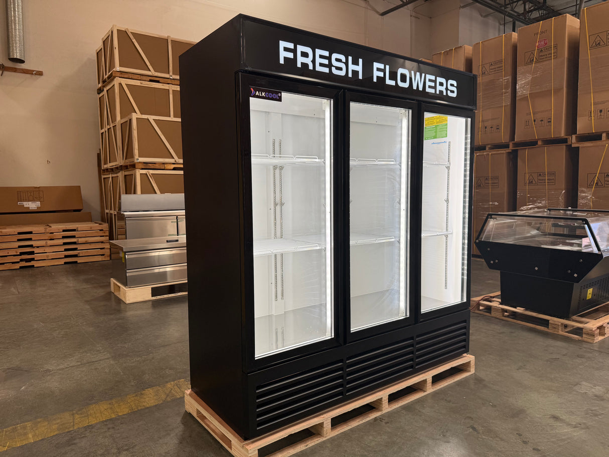 Black 'Fresh Flowers' display case in a warehouse setting with cardboard boxes and pallets.