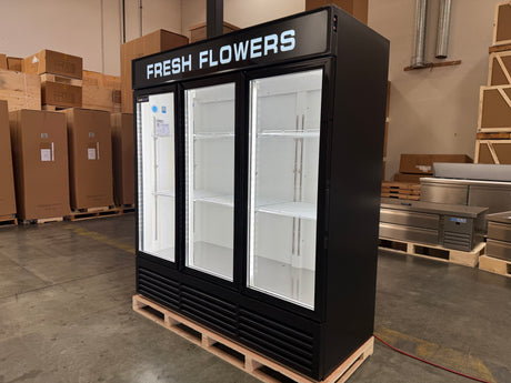Black refrigerator labeled 'Fresh Flowers' in a warehouse setting