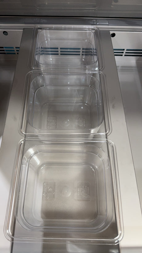Clear plastic containers stacked inside a metal compartment