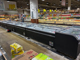 Supermarket interior with refrigerated display cases and shelves stocked with products.