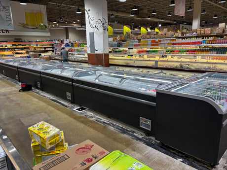 Supermarket interior with refrigerated display cases and shelves stocked with products.