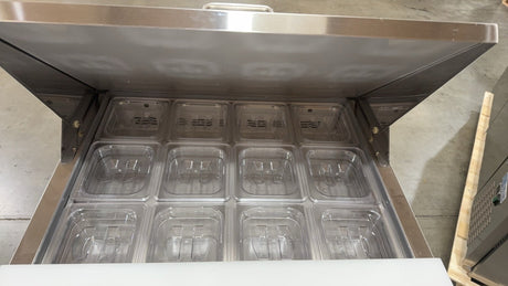 Stainless steel refrigerator with open door showing multiple compartments.