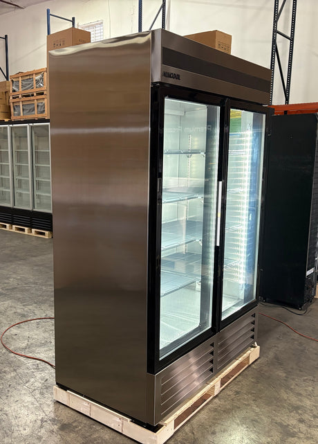 Stainless steel commercial refrigerator on a pallet in a warehouse setting
