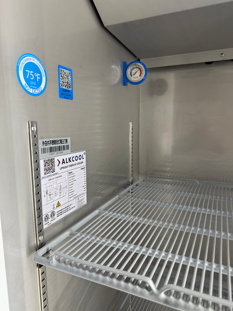 Interior of a refrigerator with temperature labels and a brand label.