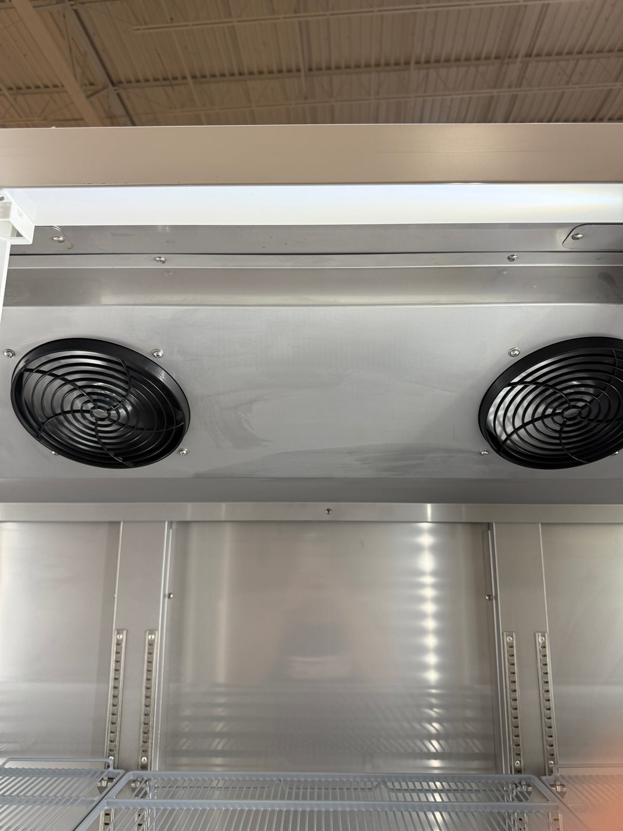 Metallic industrial unit with fans and shelves in a storage or warehouse setting