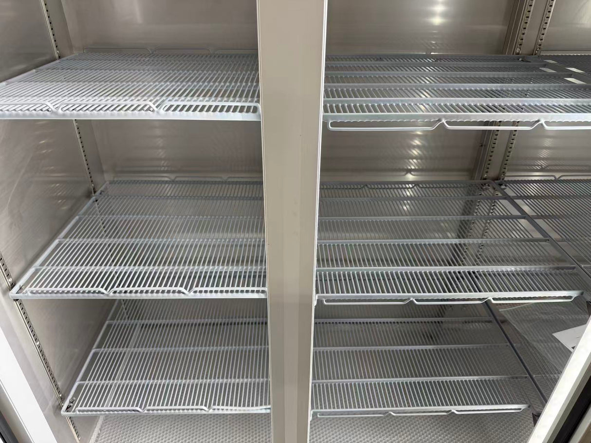 Empty metal shelves inside a refrigerator or freezer unit.