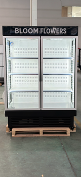Commercial refrigerator with 'Bloom Flowers' branding on a pallet.