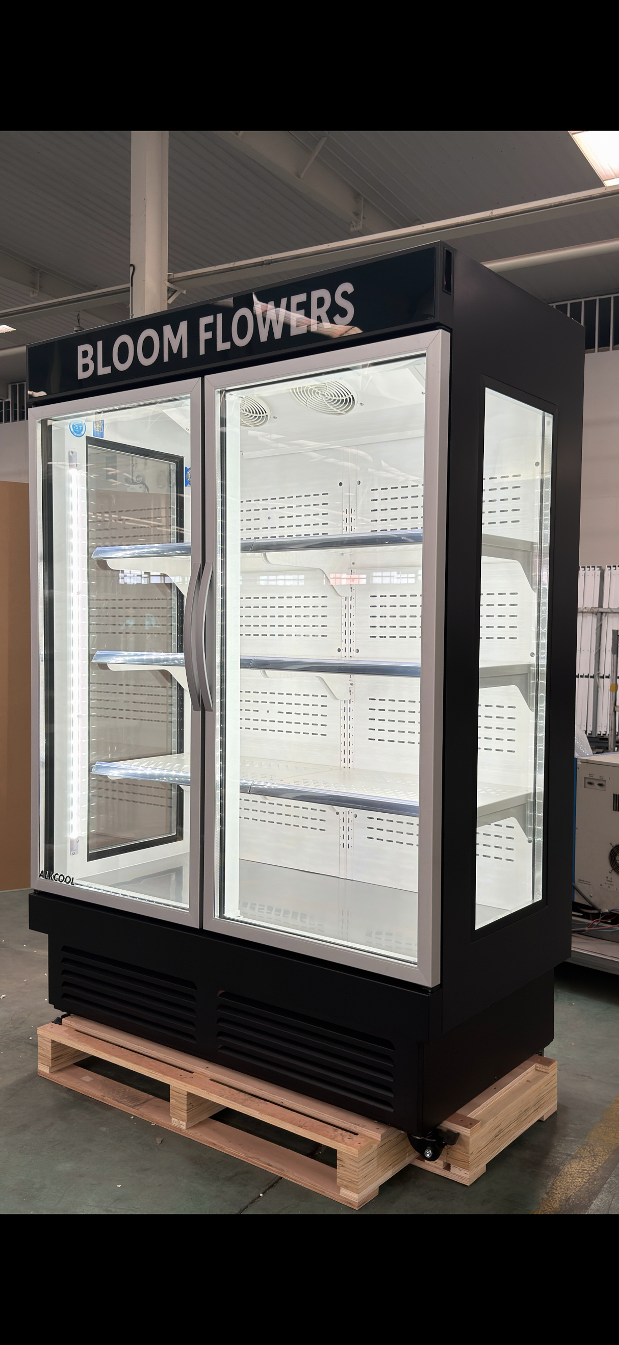 Bloom Flowers branded freezer on a pallet in an indoor setting