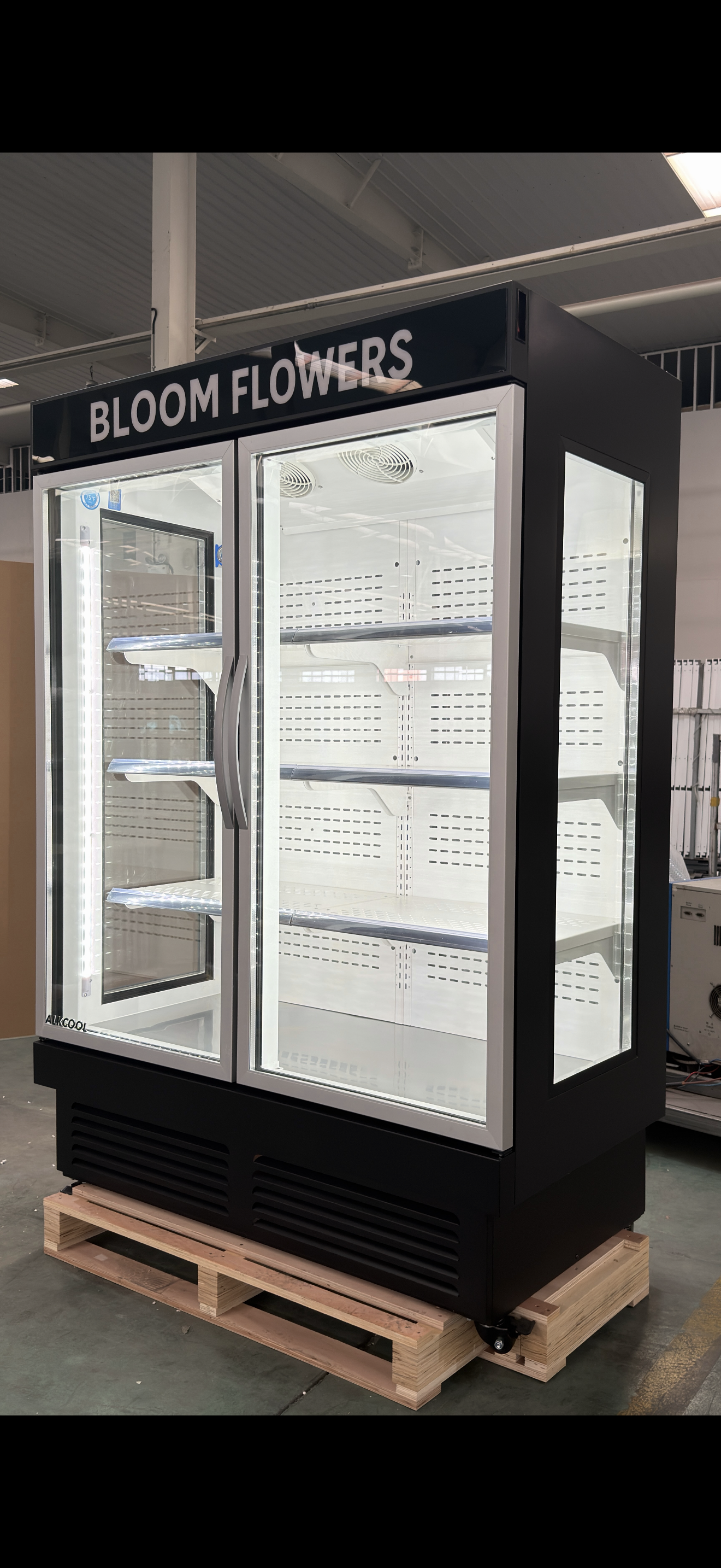 Bloom Flowers branded freezer on a pallet in an indoor setting