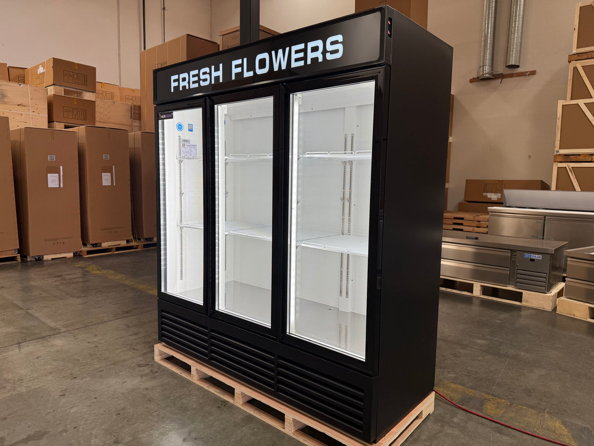 Black refrigerator labeled 'Fresh Flowers' in a warehouse setting