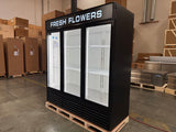 Black refrigerator labeled 'Fresh Flowers' in a warehouse setting
