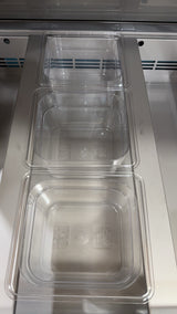 Clear plastic containers stacked inside a metal compartment