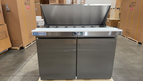 Stainless steel kitchen island with cooktop in a warehouse setting