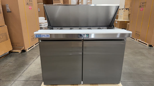 Stainless steel kitchen island with cooktop in a warehouse setting