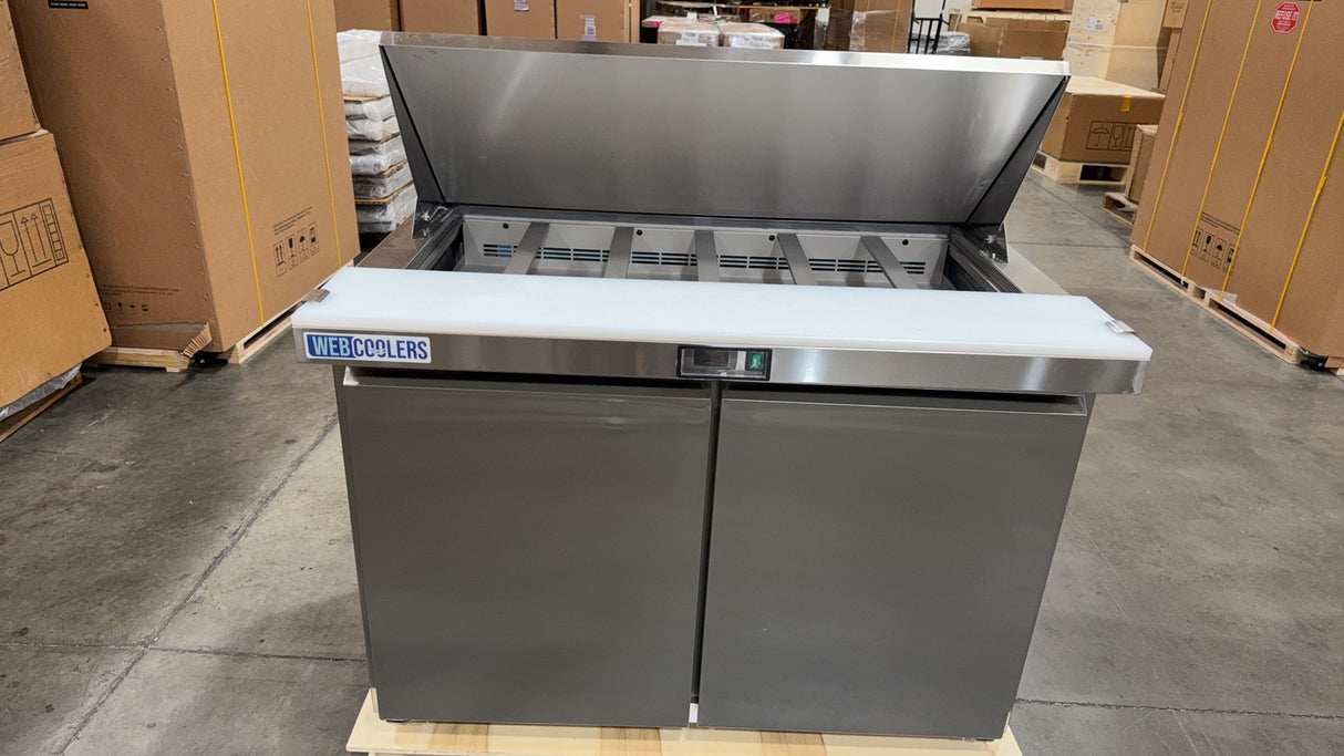 Stainless steel refrigerator on a pallet in a warehouse setting